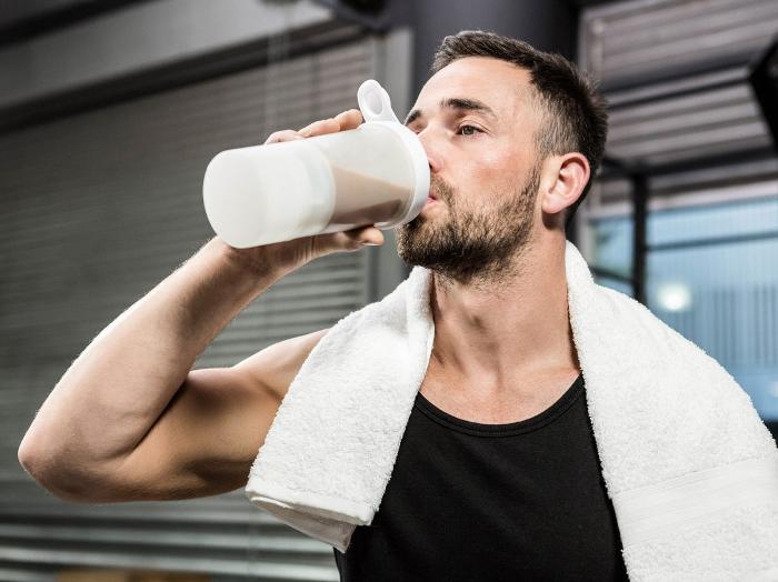 Sport Supplement store man drinking protein